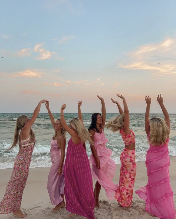 women in pink dresses dancing on the beach sourced from pinterest