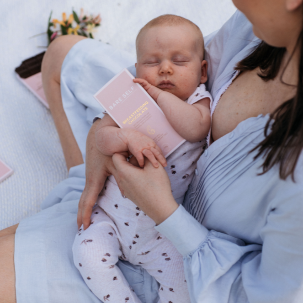 Mother with baby, newborn, breastfeeding, Bare Self breastfeeding chocolate in baby's hands.